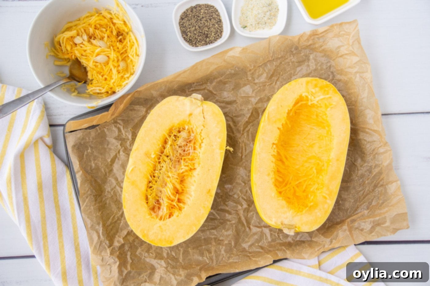 Spaghetti squash carefully cut in half lengthwise, revealing the seeds and stringy flesh inside.