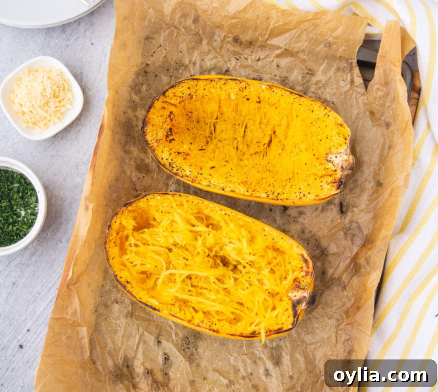 Baked spaghetti squash halves with a slightly browned top, resting on a baking tray.