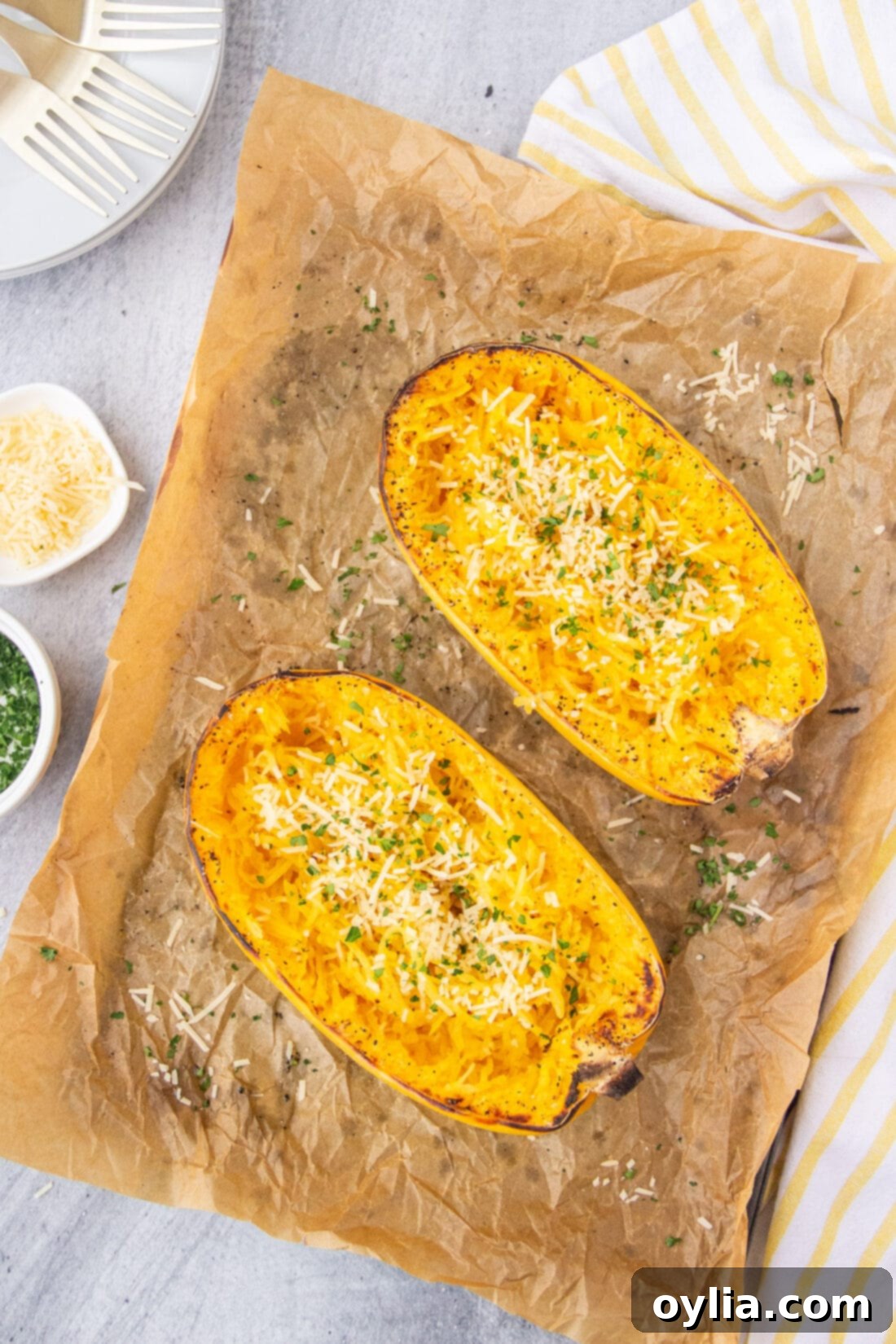 Golden Spaghetti Squash Bake 9 Two halves of perfectly baked spaghetti squash with golden-brown edges, resting on parchment paper on a baking sheet, garnished with fresh parsley.