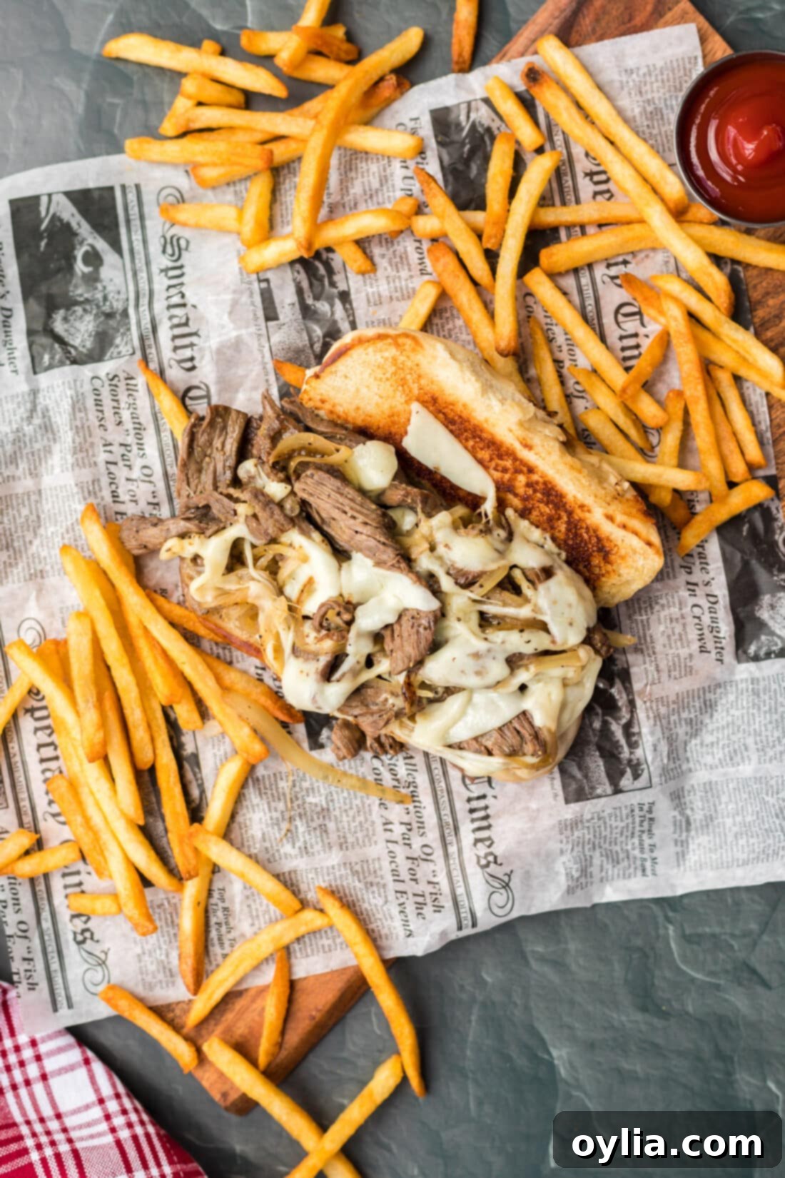 Philly Cheese Steak on parchment with fries