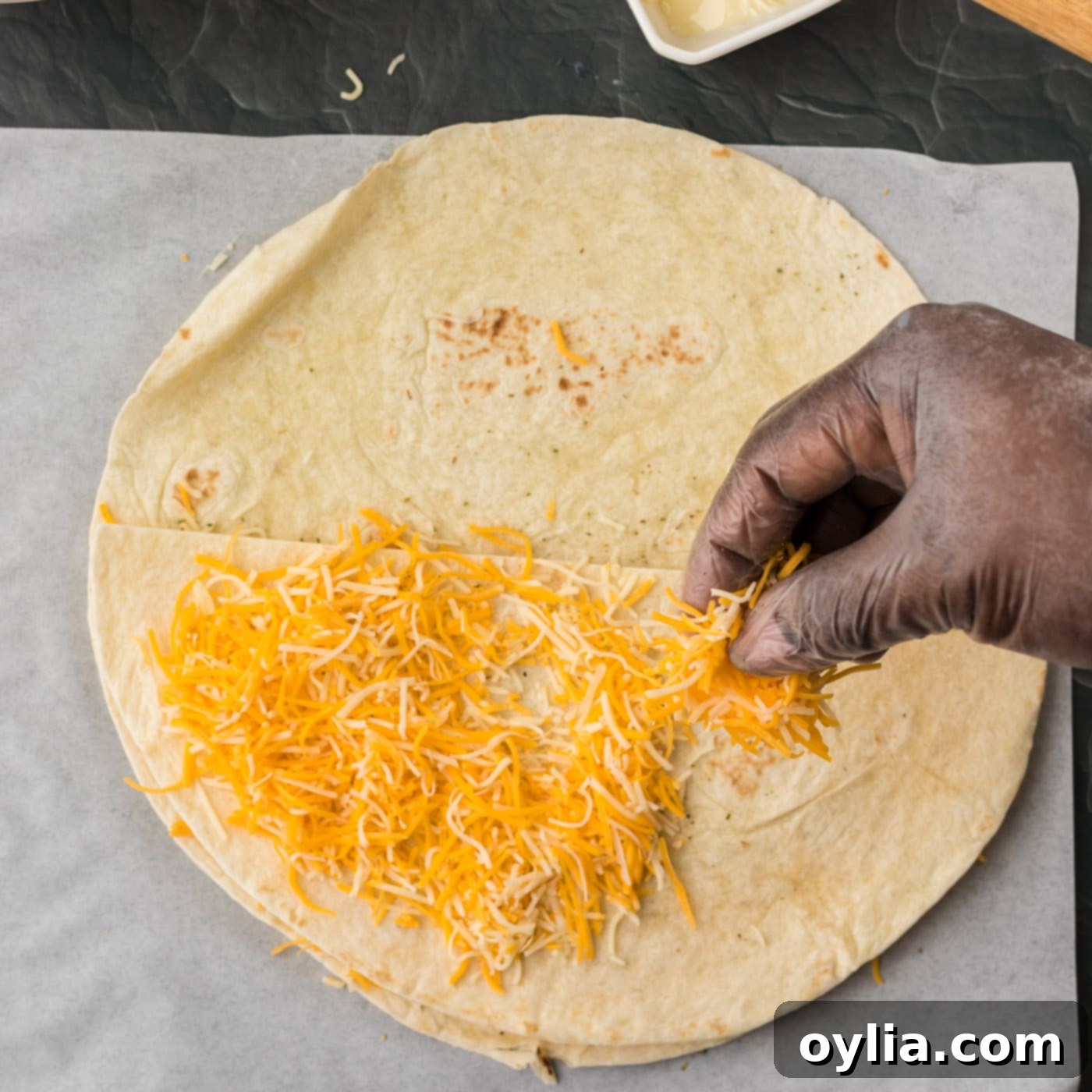 sprinkling cheese over folded quesadilla