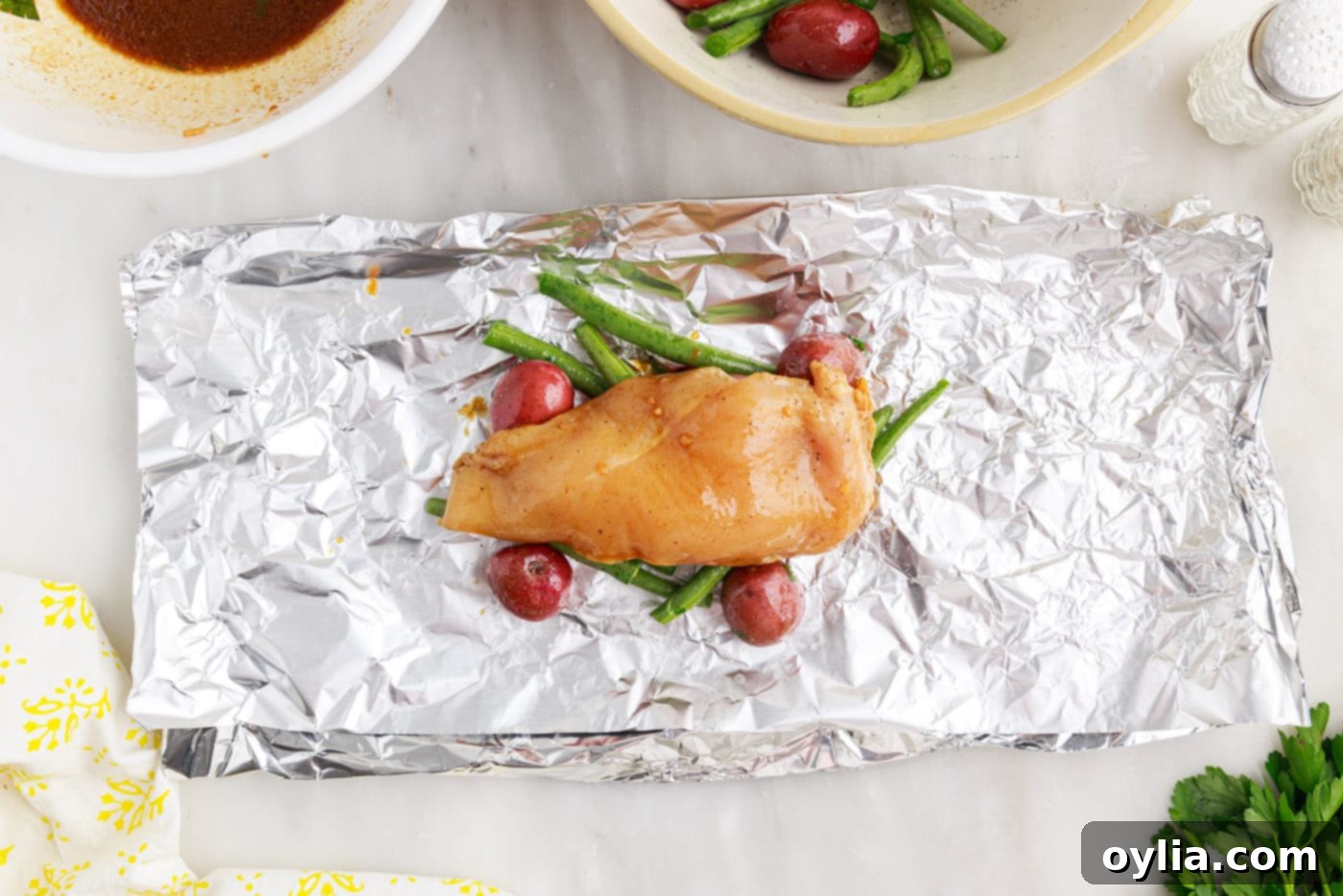 chicken over green beans and potatoes in a foil packet