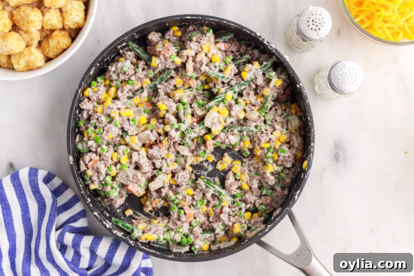 stirred tatertot casserole ingredients in a skillet