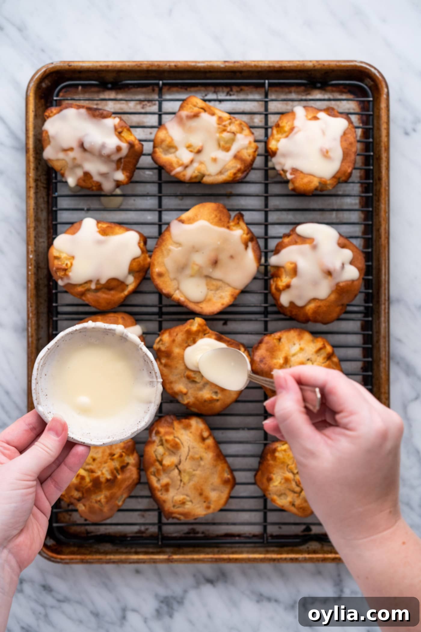 spooning glaze over apple fritters