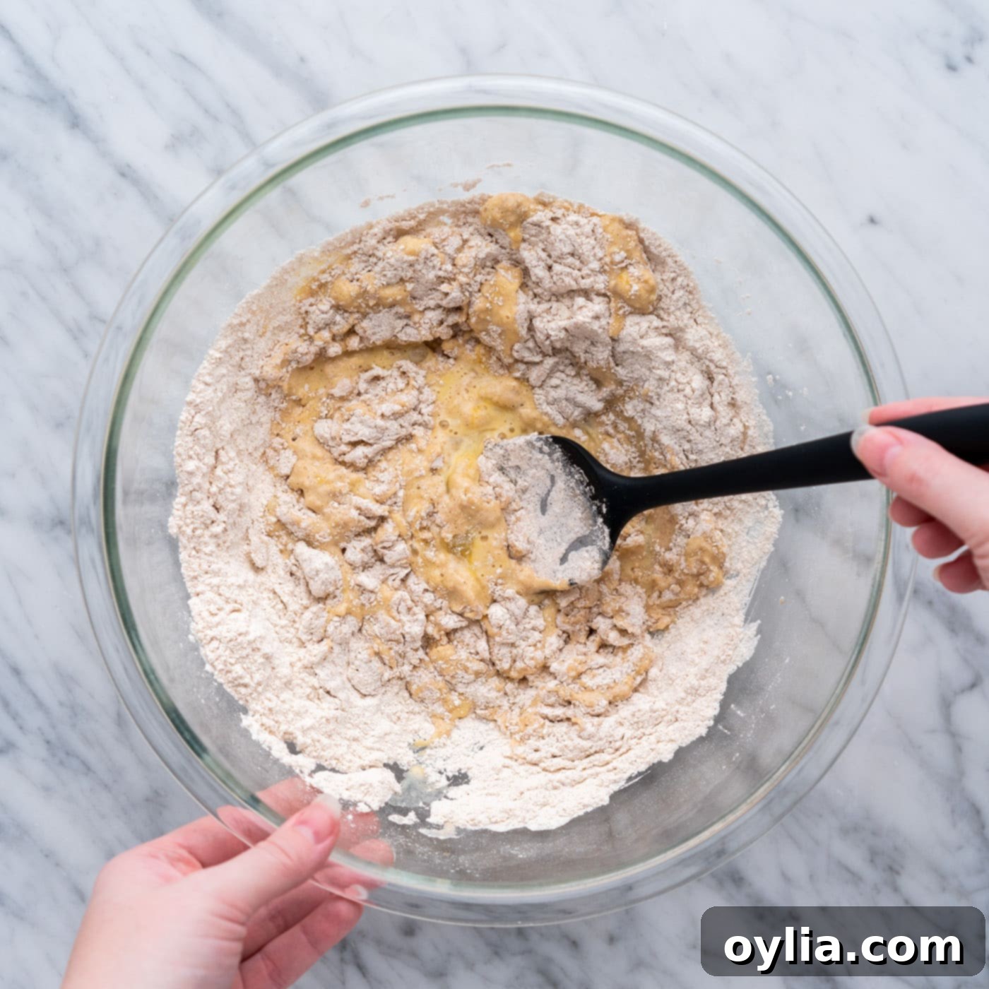 mixing apple fritter batter in a bowl with spatula