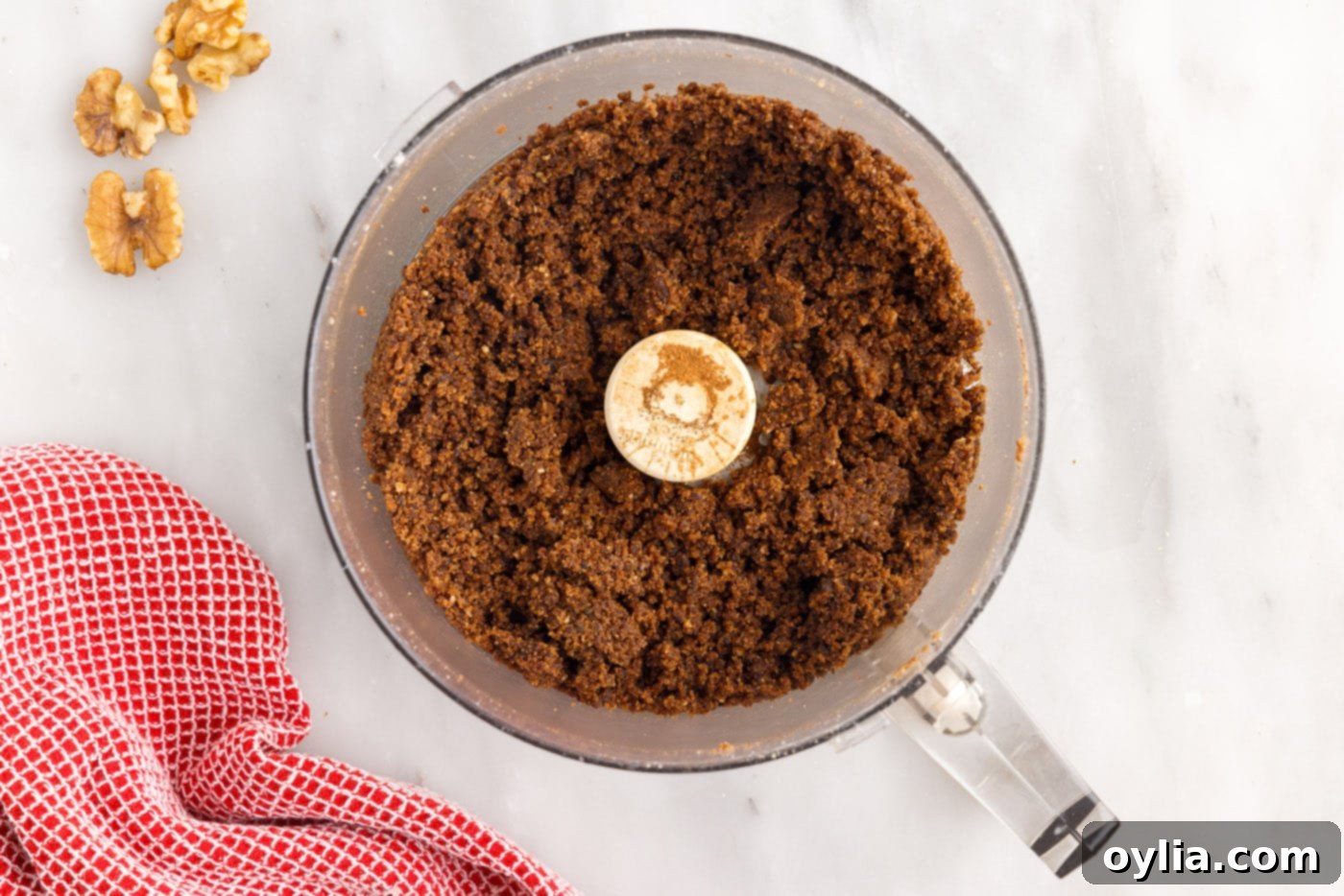 A close-up of the walnut, raisin, cinnamon, and brown sugar filling mixture in a food processor, finely chopped and ready for use.