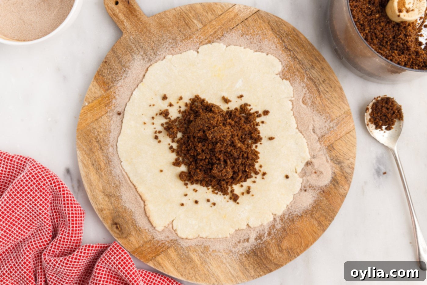 The rugelach dough disc covered with an even layer of walnut, raisin, and cinnamon filling, leaving a small border.