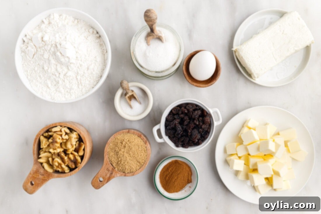 Various ingredients for making Rugelach cookies laid out on a wooden surface, including flour, butter, cream cheese, walnuts, and raisins.