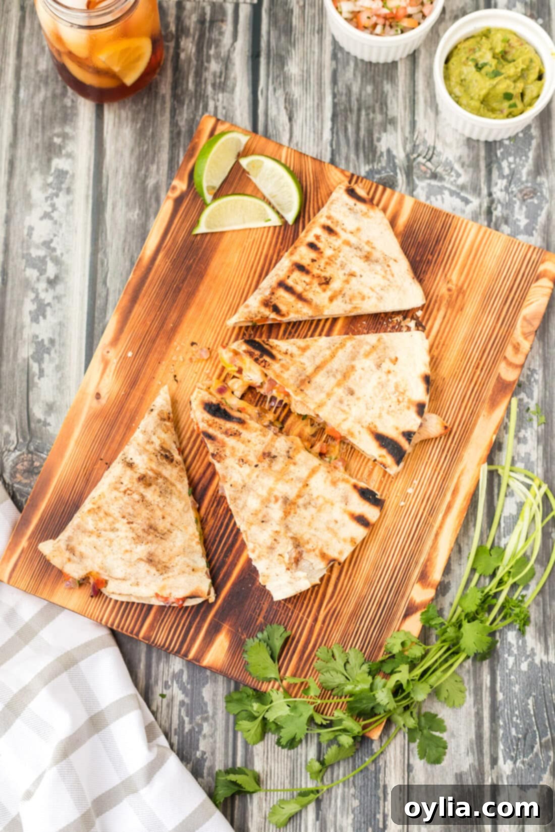 Ultimate Grilled Chicken Quesadilla 3 Grilled chicken quesadilla sliced into triangles on a wooden cutting board