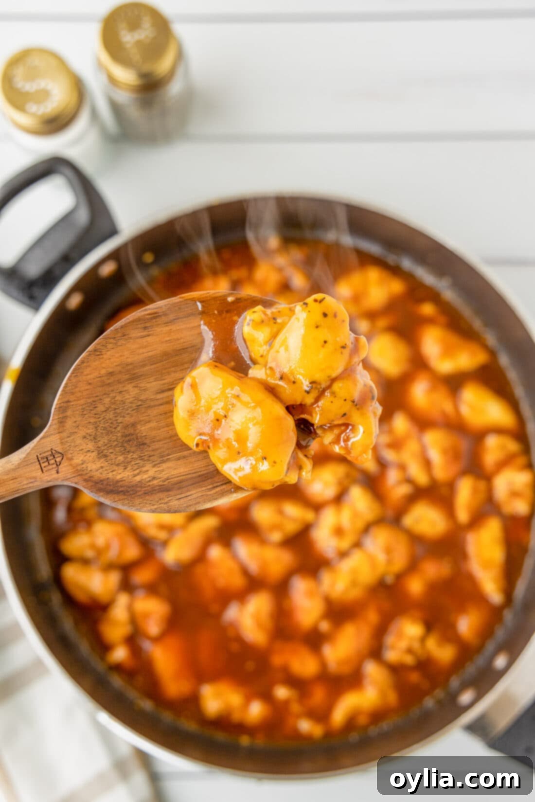 spoon of Bourbon Chicken over skillet