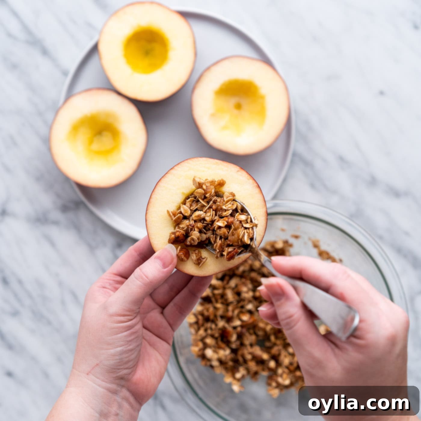 Scooping walnut and brown sugar filling into apples