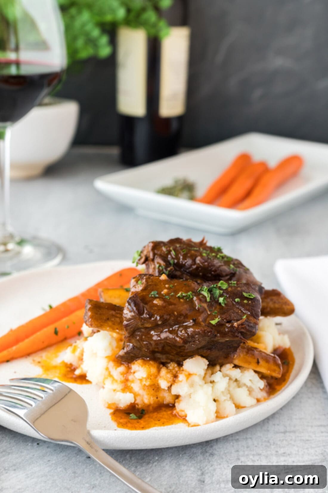 Instant Pot Beef Short Ribs on a plate, garnished with fresh herbs and served with mashed potatoes
