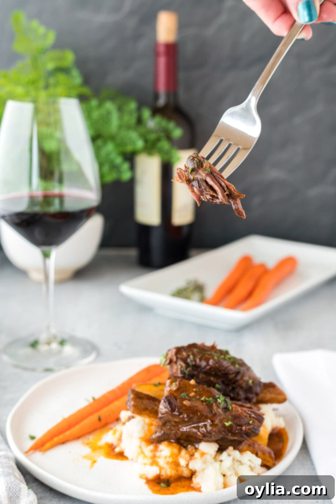 A fork full of Instant Pot Beef Short Ribs, showcasing their tenderness and rich gravy