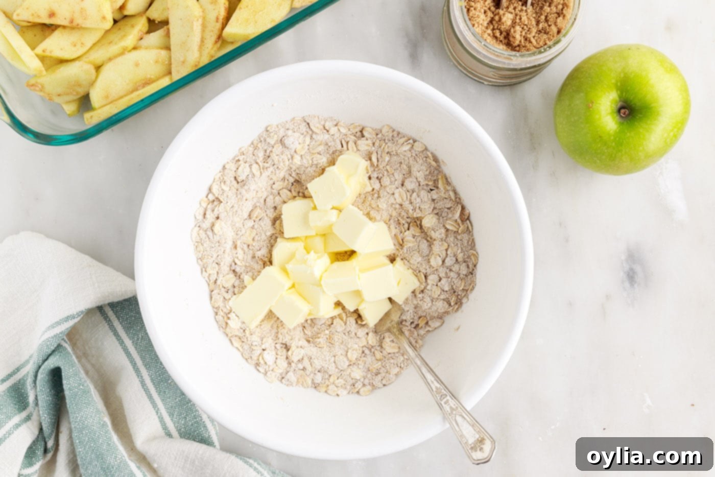 Cubed cold butter added to the dry rolled oats and flour mixture