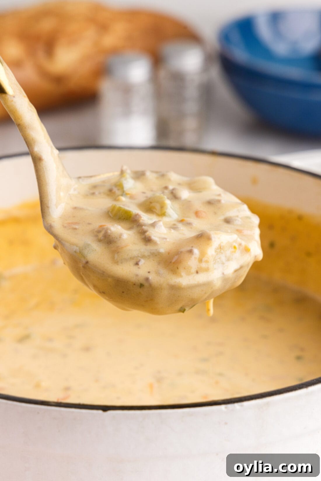 Ladle of rich and creamy homemade Cheeseburger Soup with melted cheese and ground beef