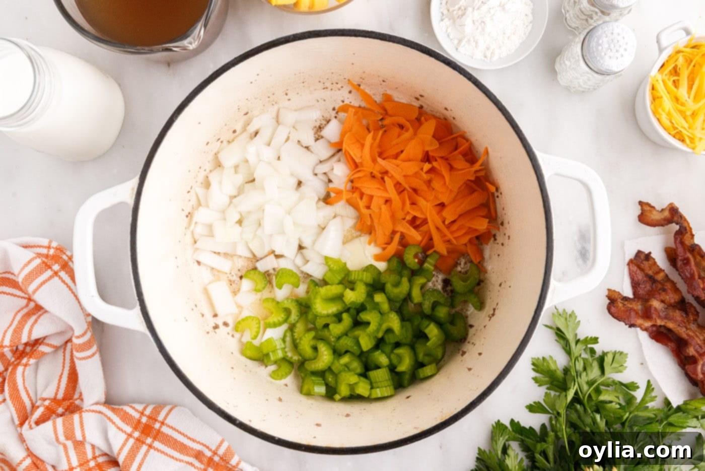 Chopped onions, celery, and grated carrots sautéing in butter in a large stockpot