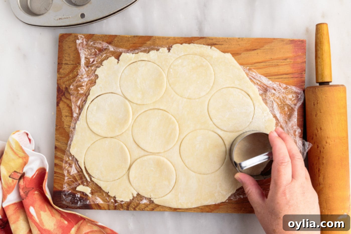Cutting pie dough into small discs using a biscuit cutter