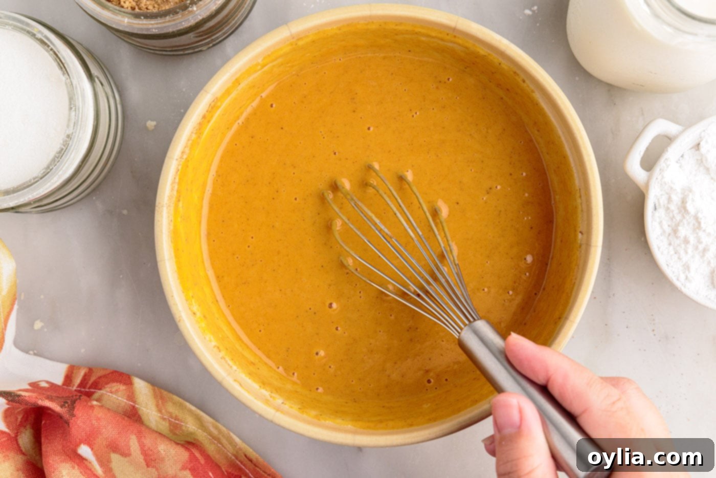 Pumpkin pie filling in a bowl with a whisk