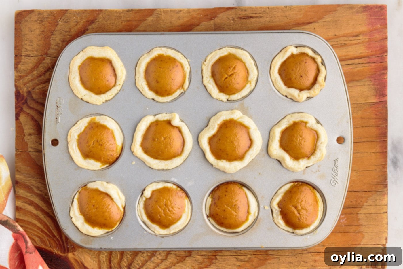 Baked mini pumpkin pies cooling in a muffin tin