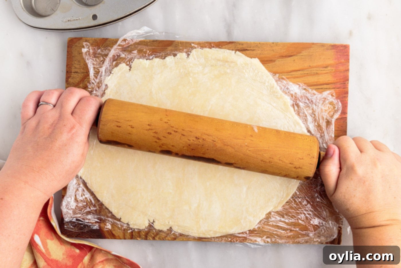 Rolling out homemade pie dough on a floured surface