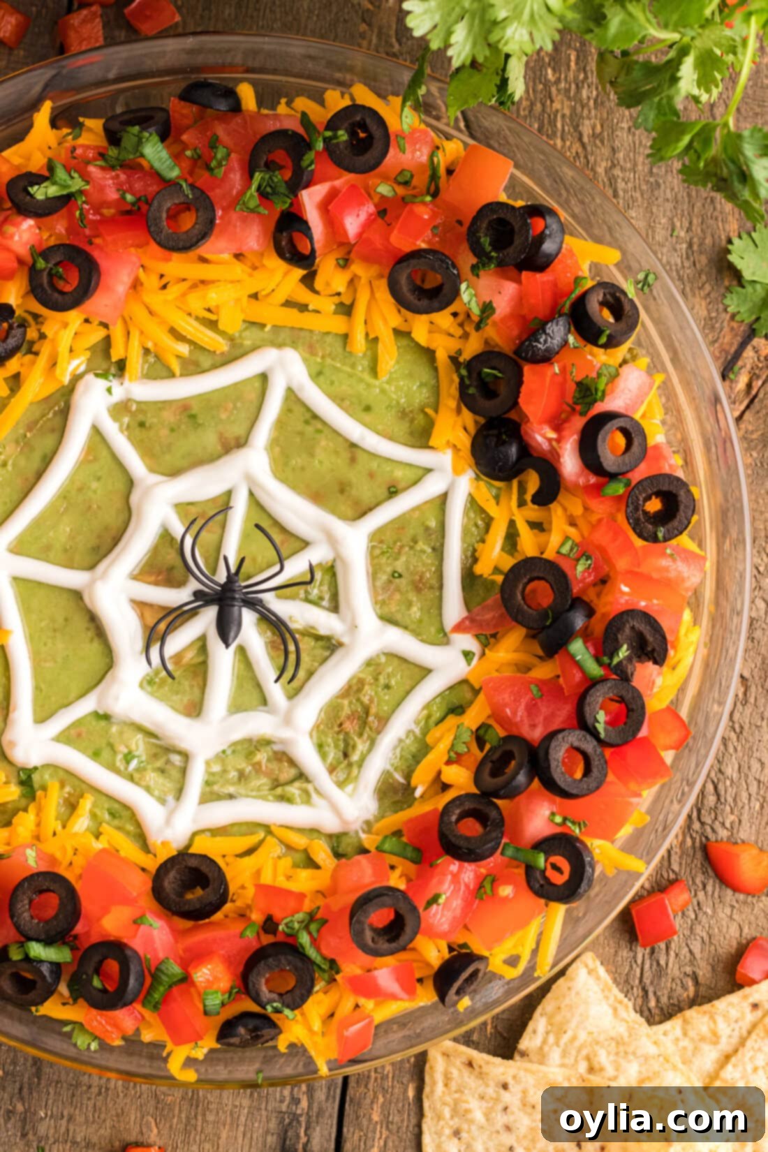 Spider Web Taco Dip with a plastic spider centerpiece, ready for a Halloween party