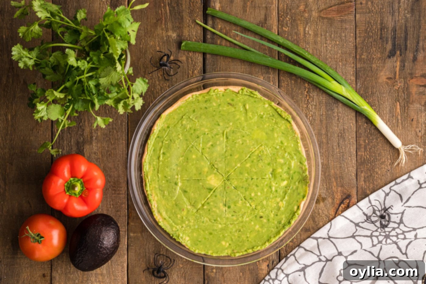 The smooth, green layer of guacamole perfectly spread over the seasoned taco dip