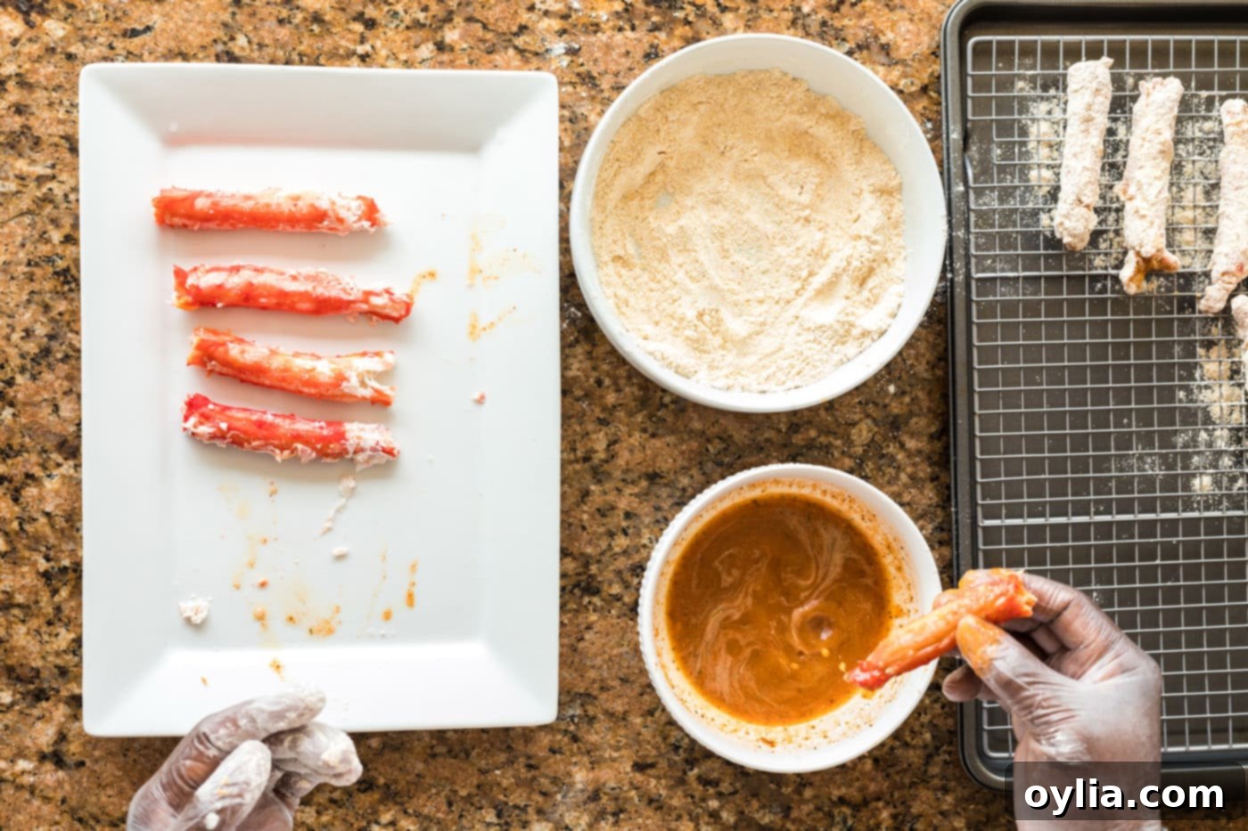 dipping crab leg into seasoned egg mixture
