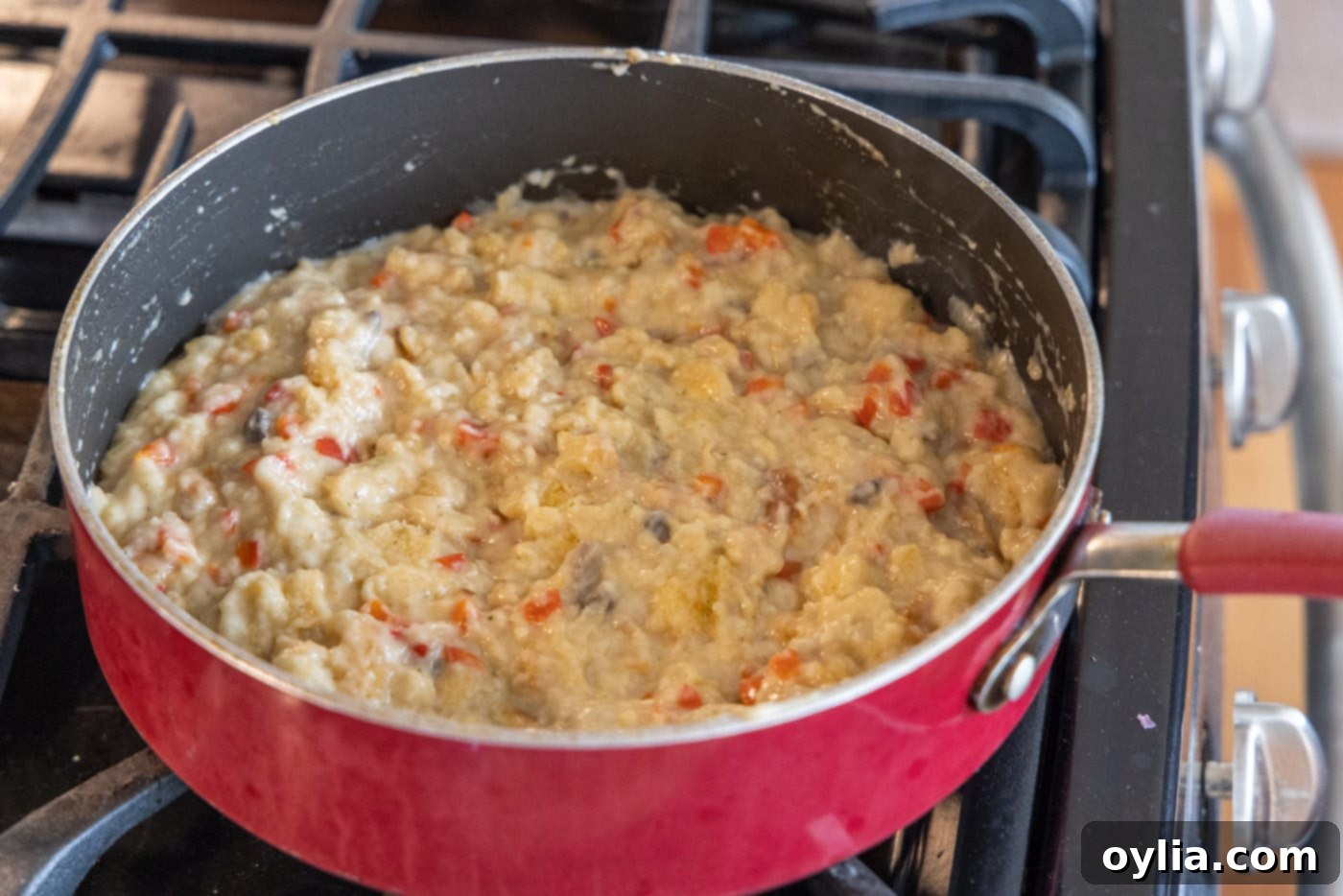 Savory stuffed chicken breast filling in a skillet, combining vegetables, croutons, and cream of mushroom soup