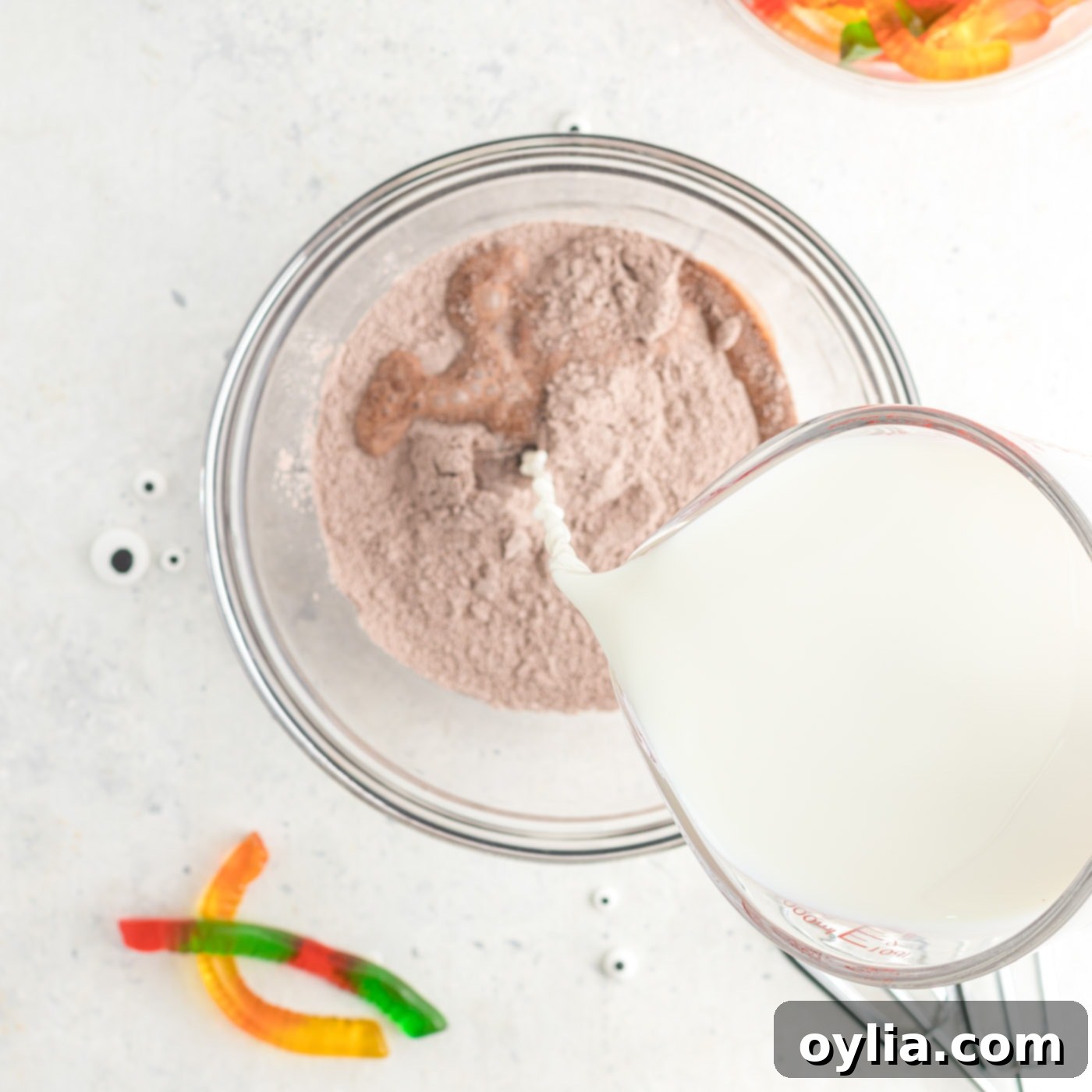 Pouring milk into a bowl with instant chocolate pudding mix.