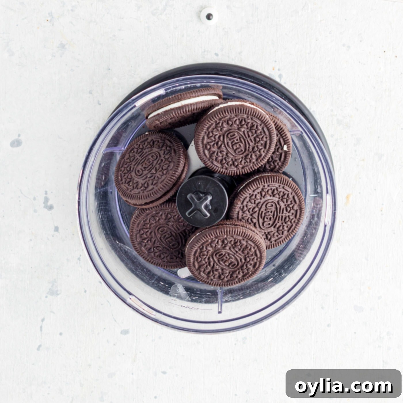 Oreo cookies placed in a food processor before crushing.