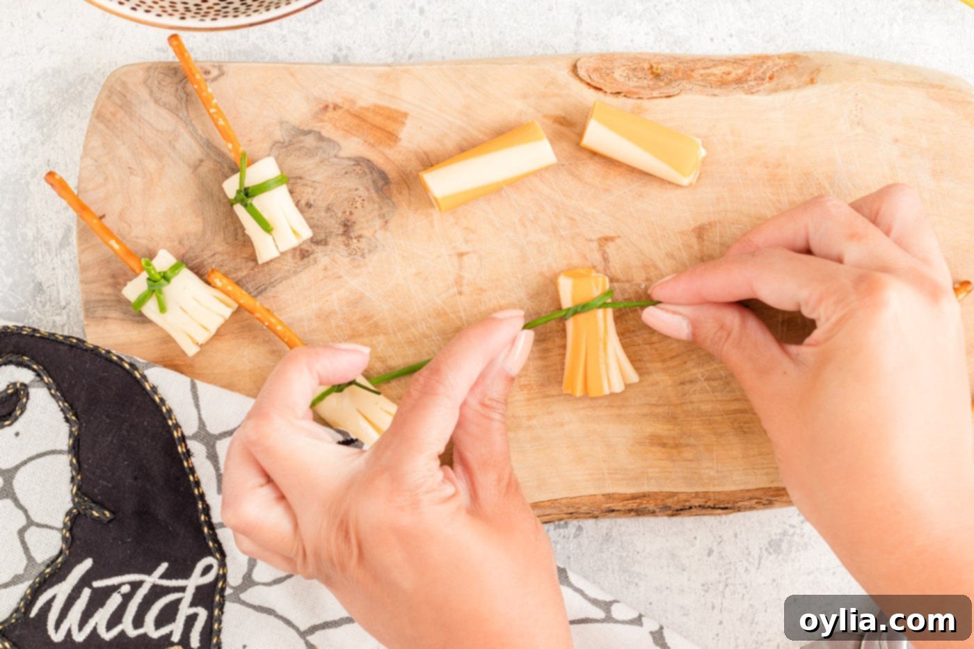 tying chive around cheese broomstick