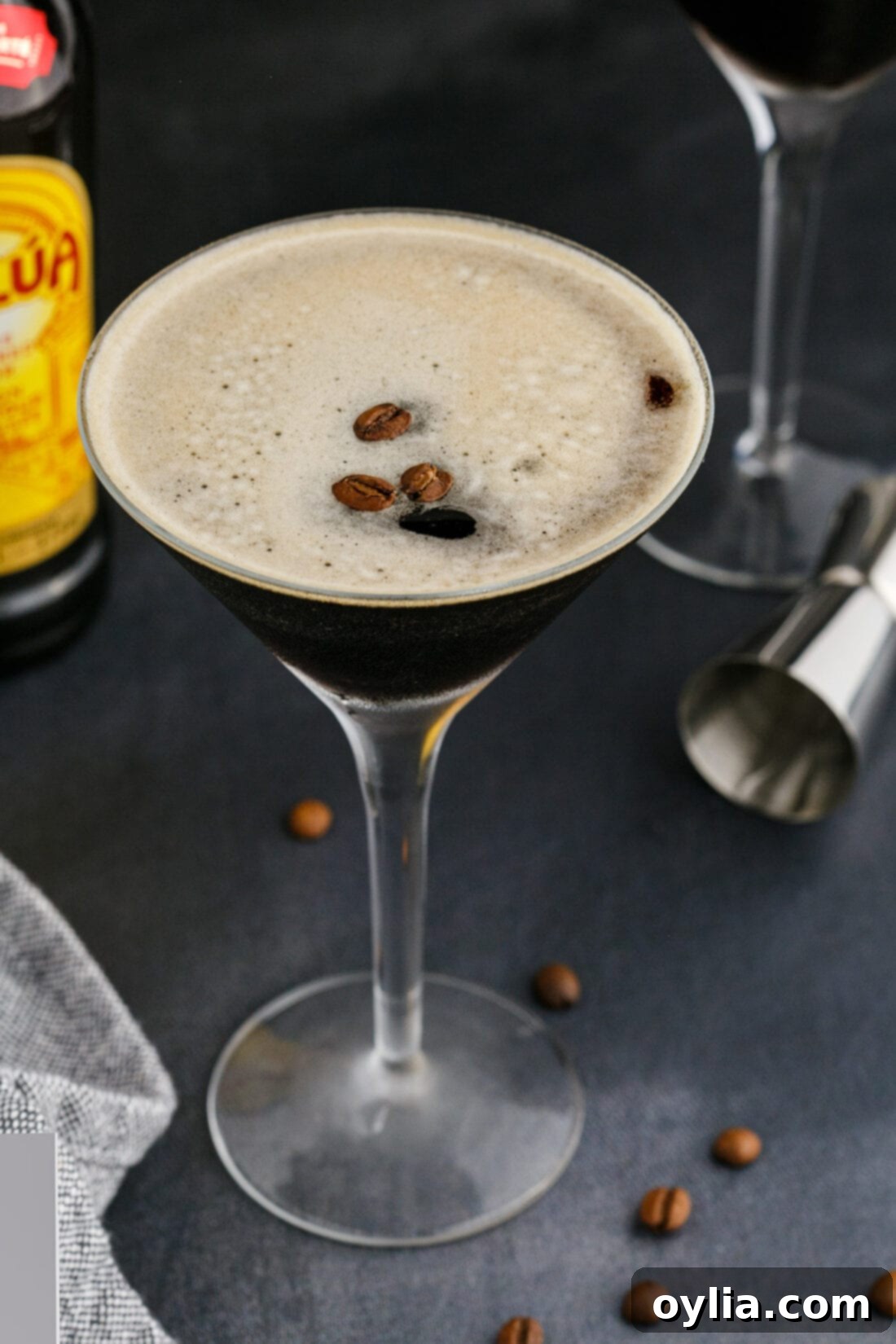 Velvet Buzz 2 A perfectly prepared Espresso Martini garnished with three coffee beans, sitting elegantly on a dark surface.