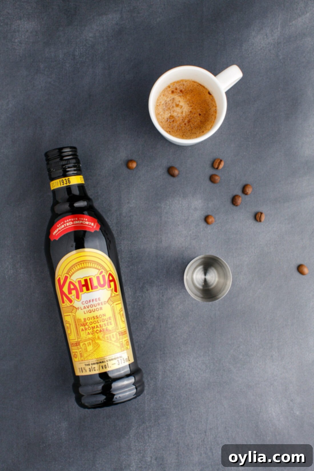 Velvet Buzz 4 All the necessary ingredients laid out for making an Espresso Martini: espresso, vodka, Kahlua, and coffee beans for garnish.