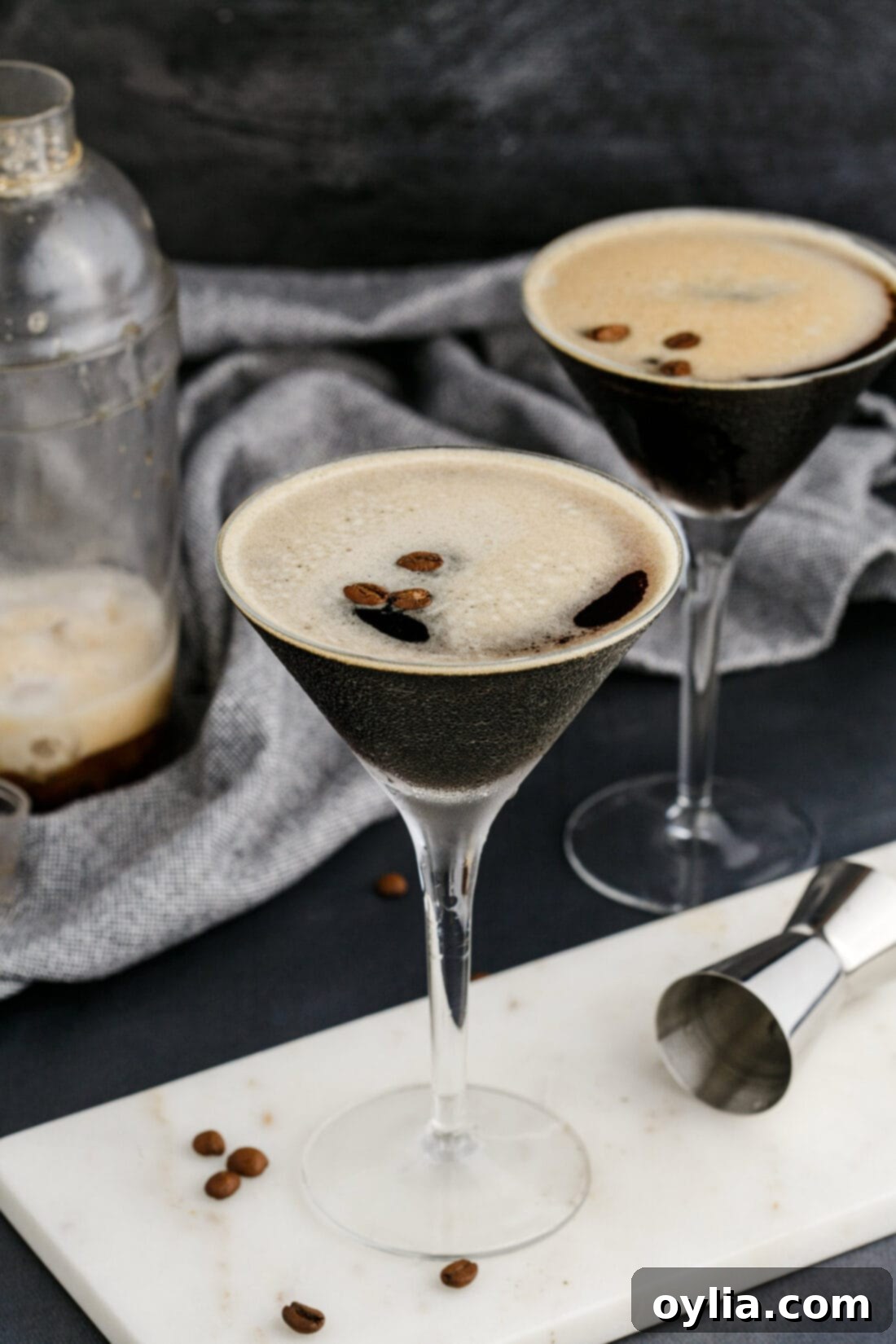 Velvet Buzz 8 Two elegantly presented Espresso Martinis in classic martini glasses, garnished with coffee beans, ready to be enjoyed.
