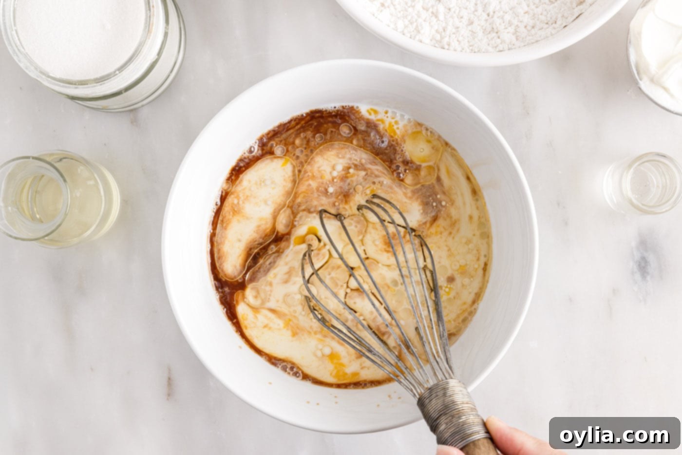 eggs, milk, oil, sour cream, and vanilla whisked in a bowl
