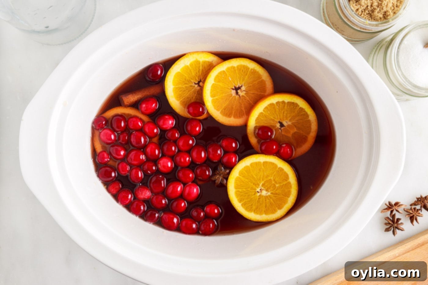 orange slices and cranberries in hot cranberry punch in the slow cooker