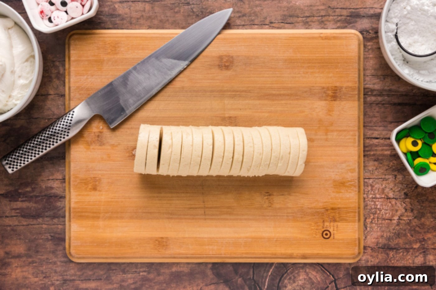 Slicing refrigerated sugar cookie dough log for mummy cookies