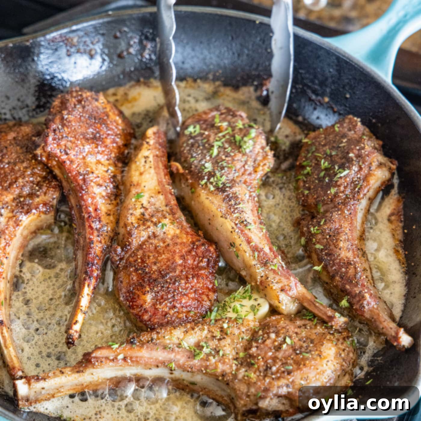 turning lamb in a skillet with butter