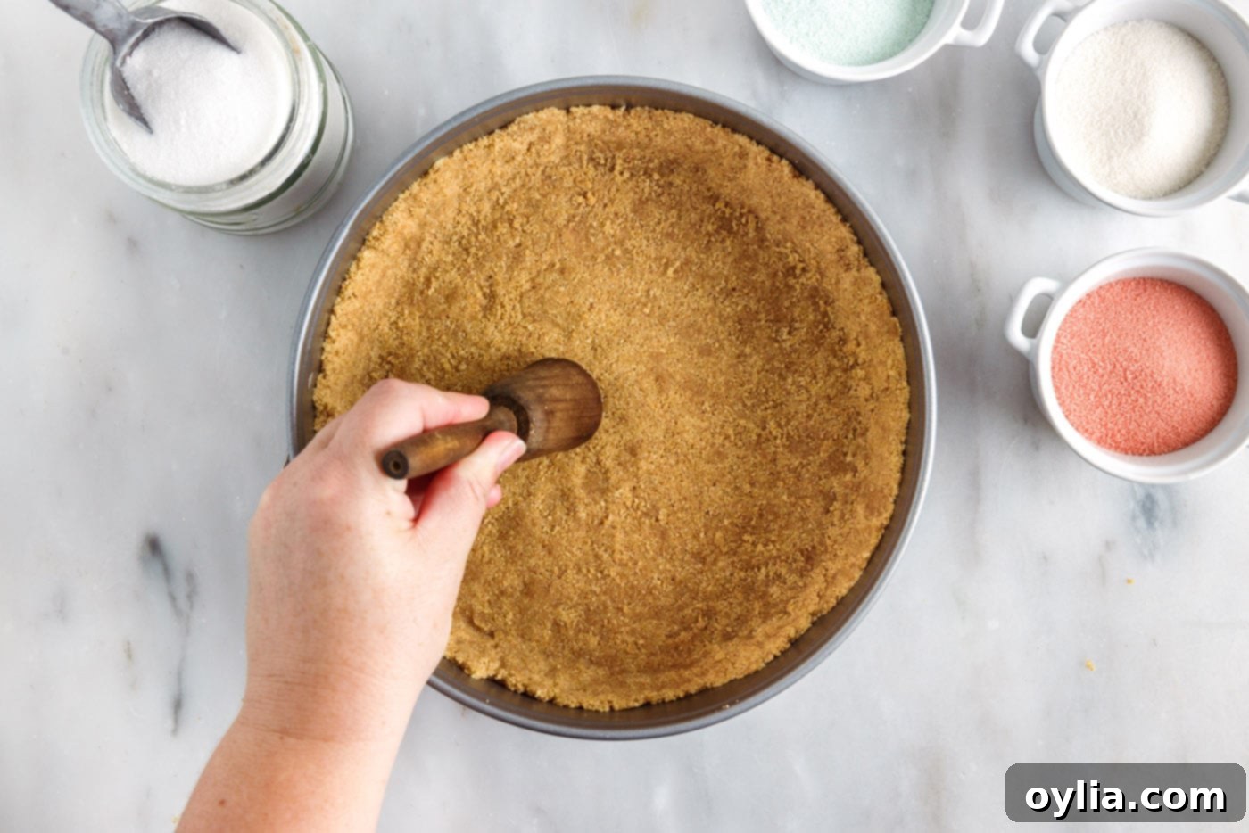 pressing graham cracker crumbs into springform pan