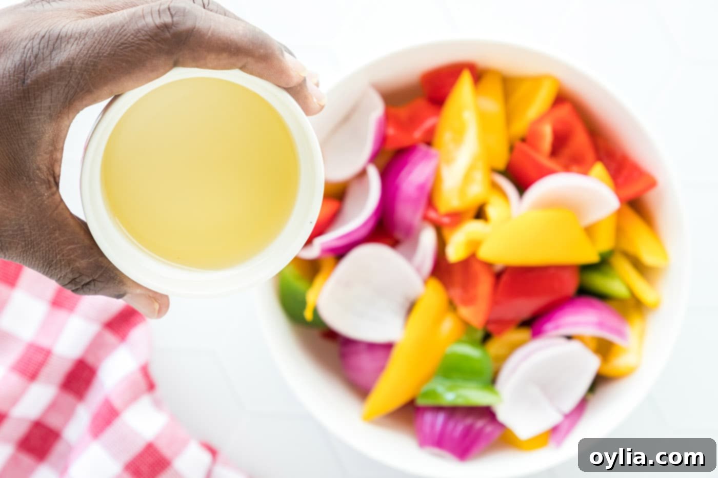 pouring oil over fresh cut veggies