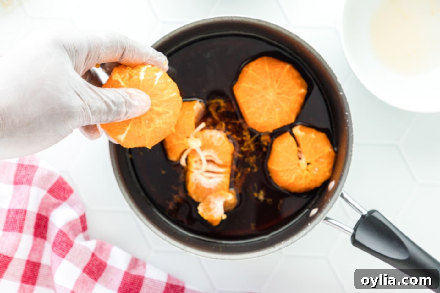 clementines added to sauce in a pan