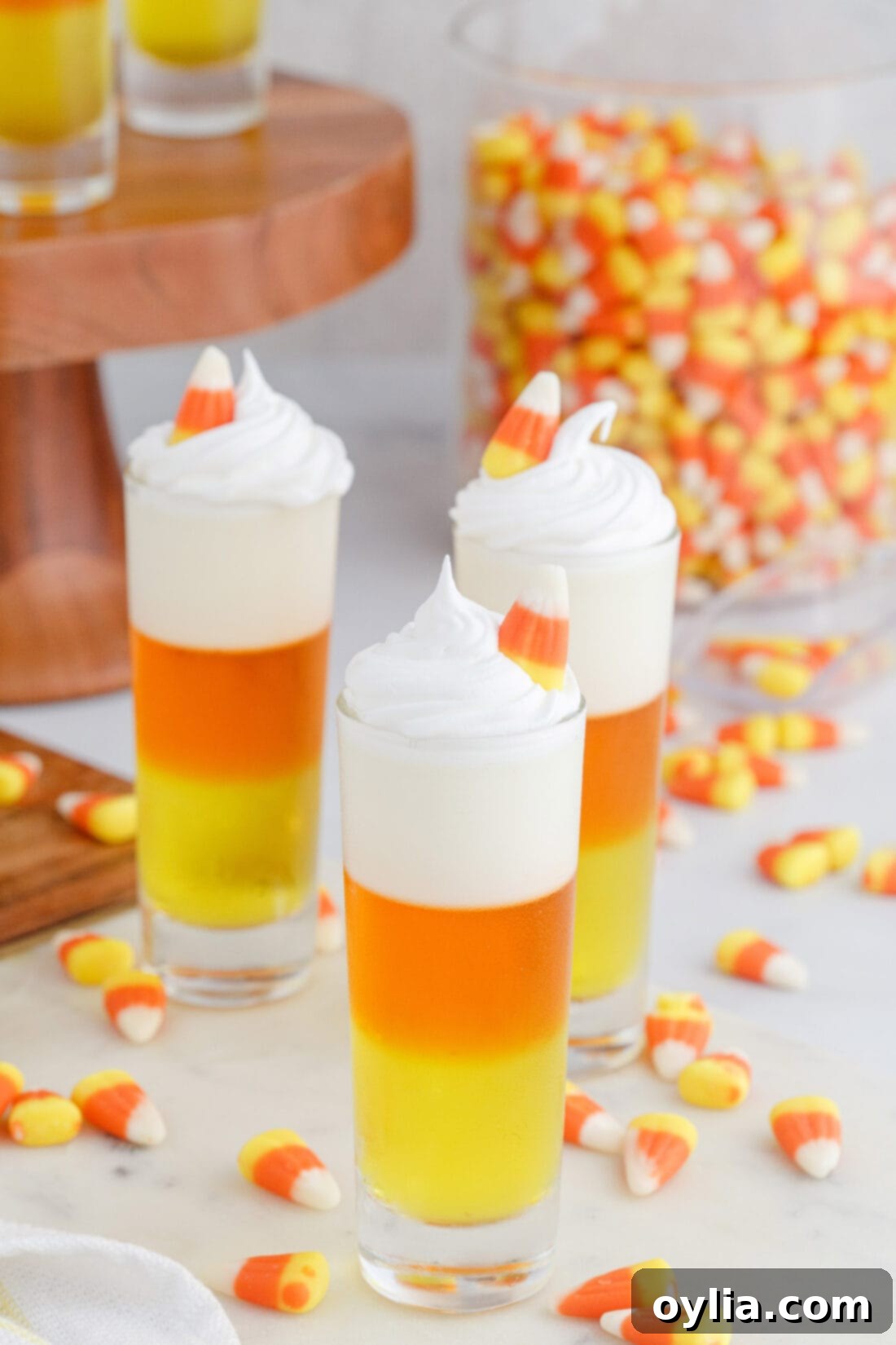 Close-up of Candy Corn Jello Shots garnished with whipped cream and candy corn