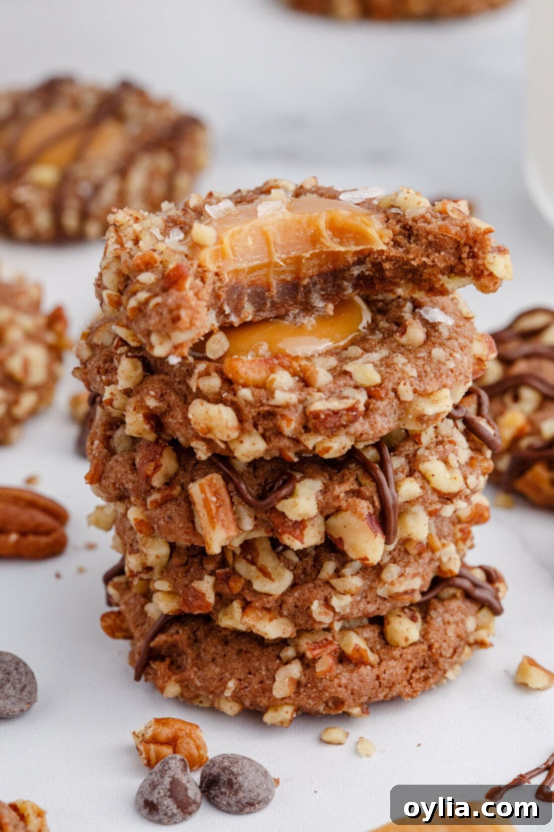 A delectable stack of Turtle Thumbprint Cookies, showing off their rich chocolate color, golden caramel centers, and pecan-studded edges.