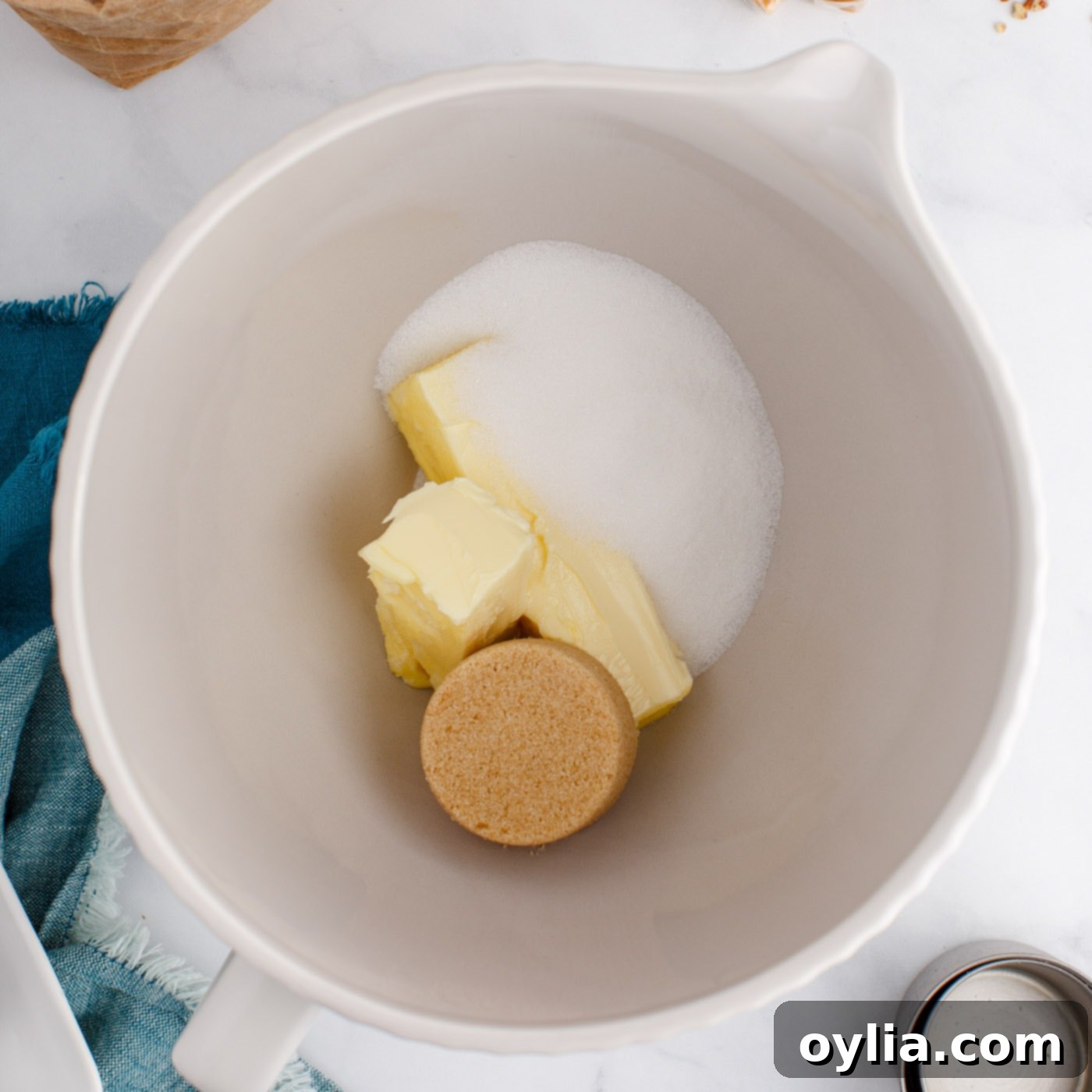 Softened butter, granulated sugar, and brown sugar being creamed together in a stand mixer bowl, turning light and fluffy.
