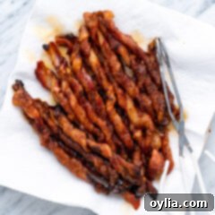 A beautiful plate of golden brown, sweet and spicy Bacon Twists, garnished and ready to serve.