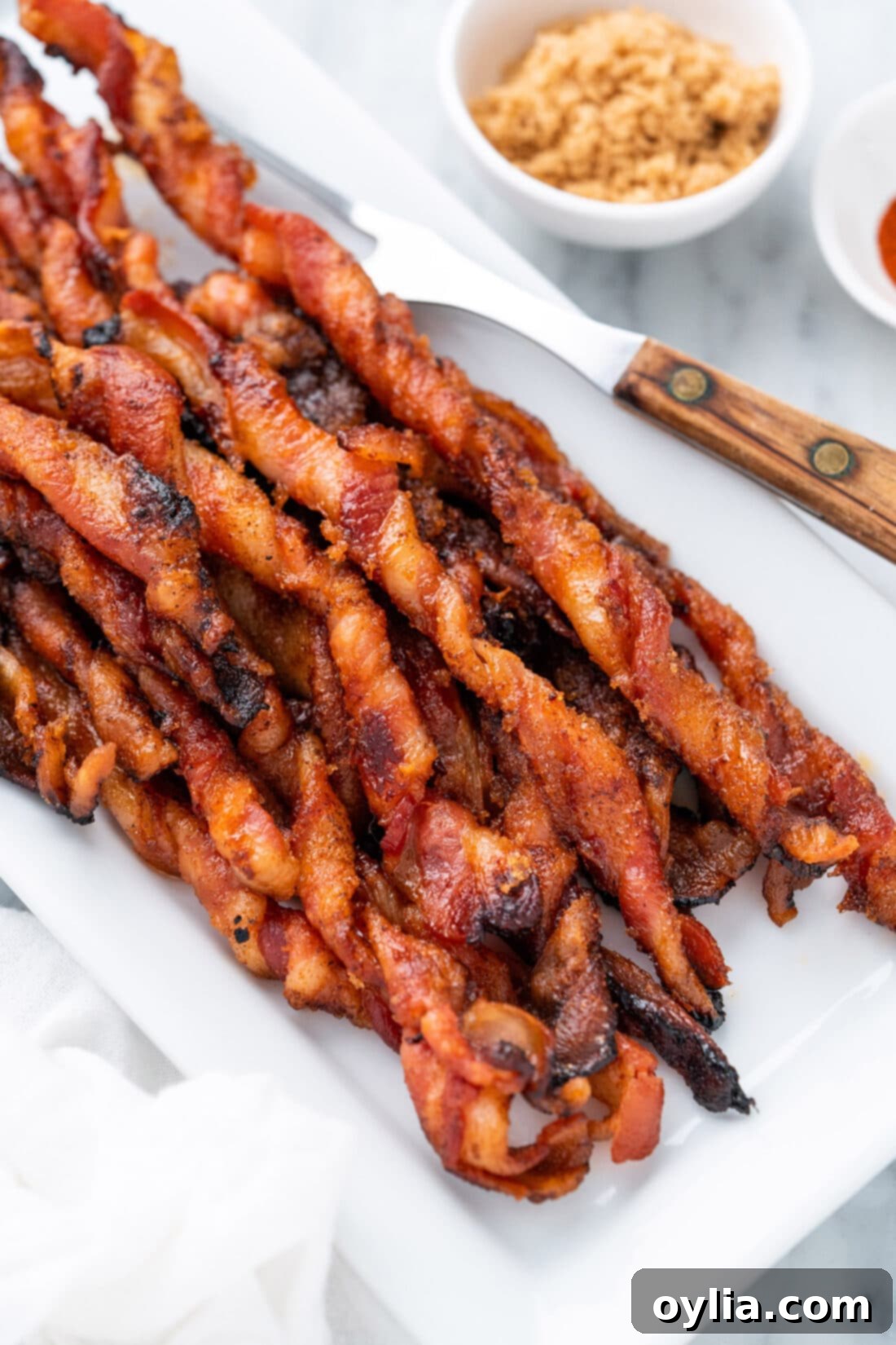 Close-up photo of a single, perfectly golden brown sweet and spicy bacon twist, showing its texture.