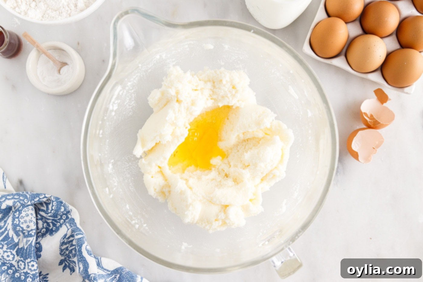 Eggs added to the shortening, butter, and sugar mixture in a bowl, being beaten