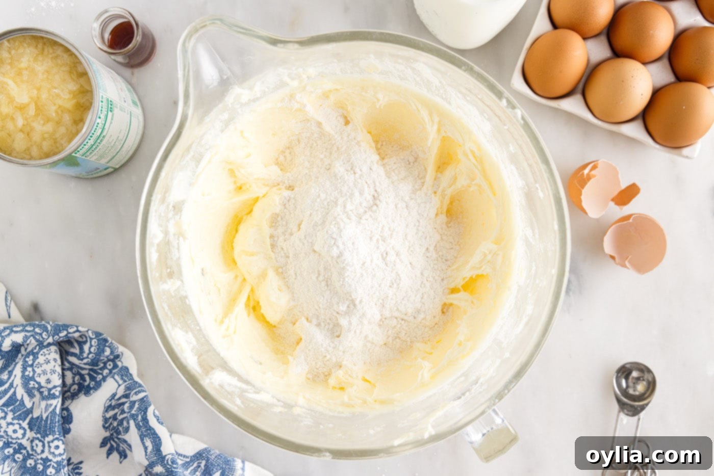 Adding flour mixture to the pound cake batter in a bowl