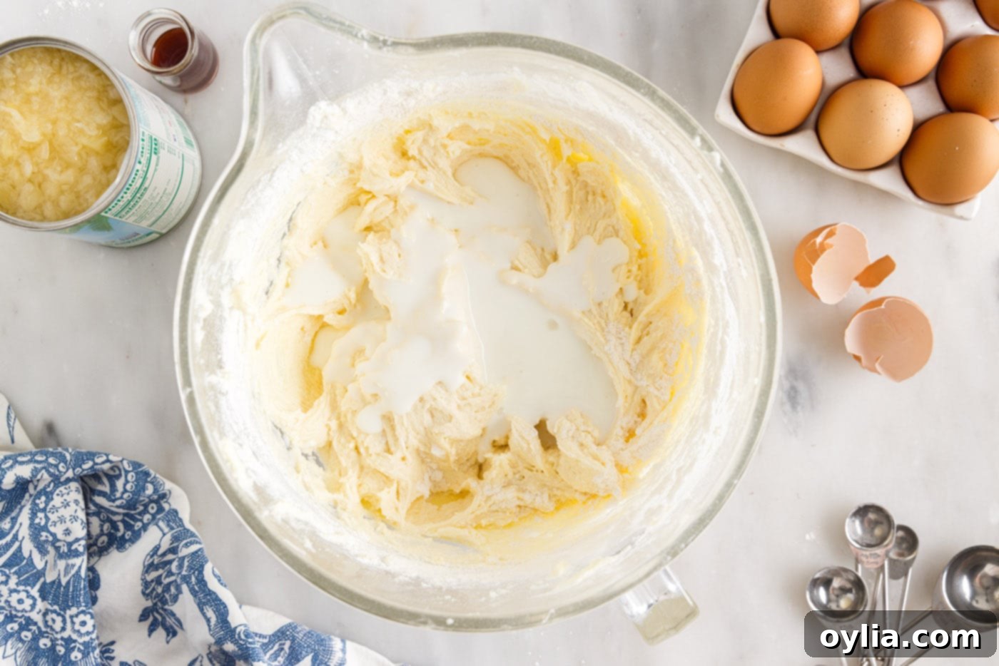 Adding buttermilk to the pound cake batter in a bowl