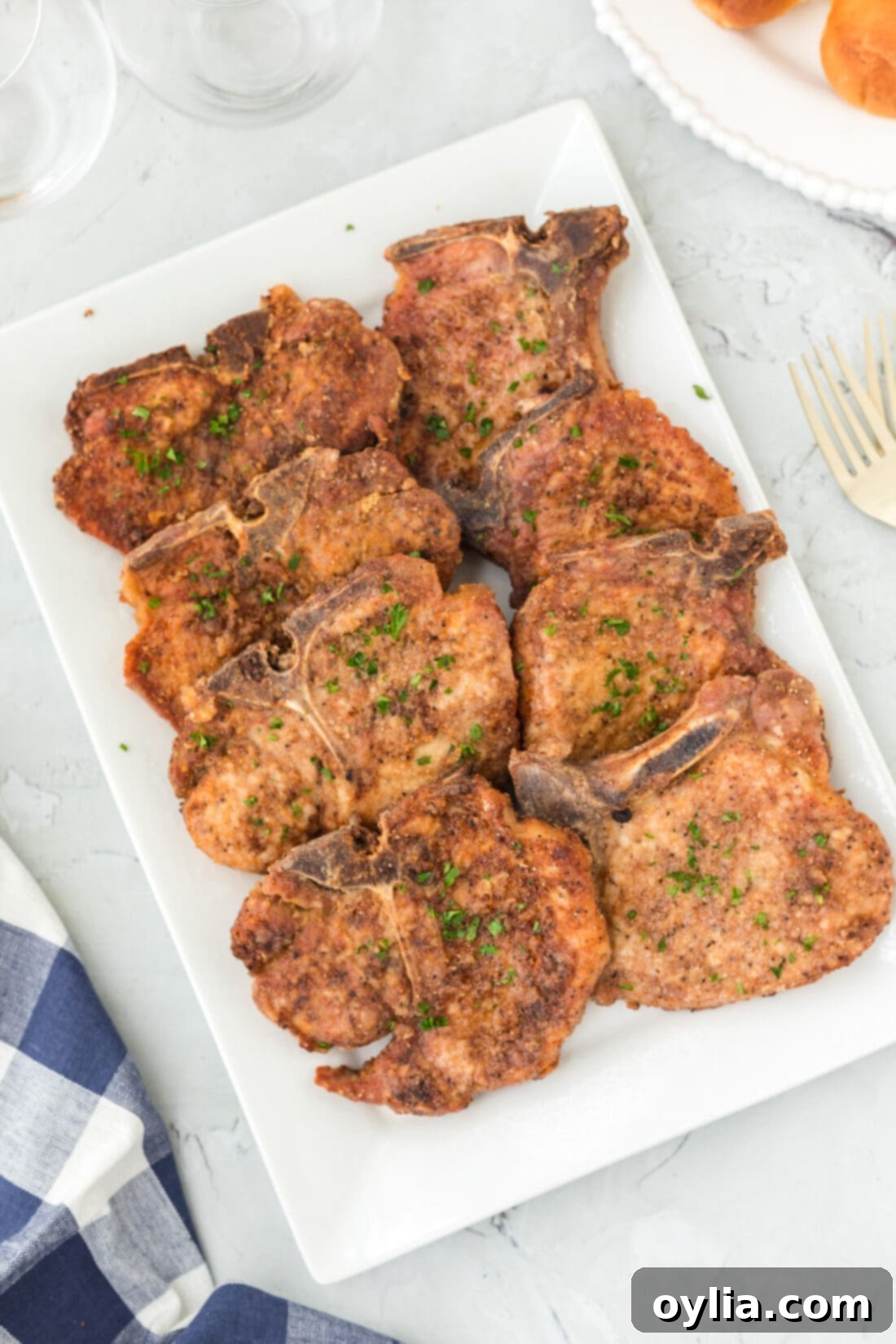 Plate of perfectly cooked, golden-brown fried pork chops, ready to serve